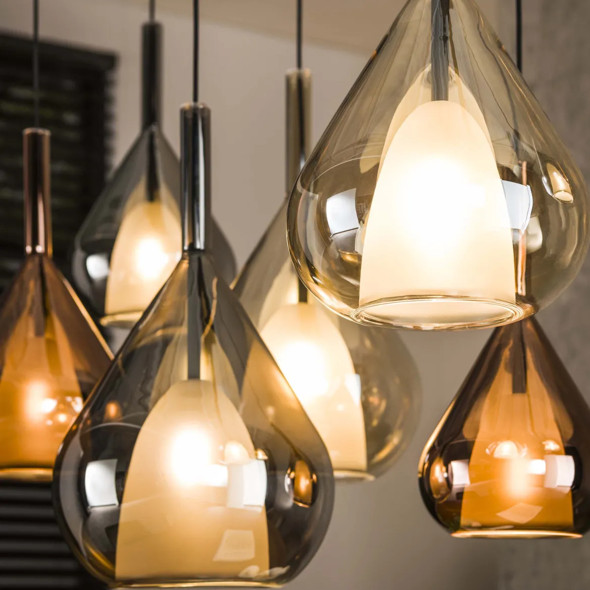 Pendelleuchte "Lumora“ – 7 tropfenförmige Glasschirme in Bernstein, Kupfer und Chrom
